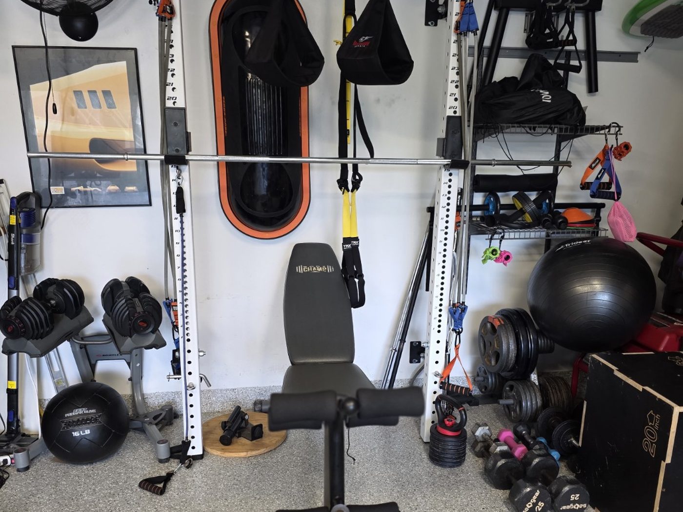 Wall-mounted folding squat rack in a shared garage